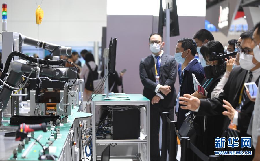 2020年11月6日,在进博会技术装备展区,人们在西门子展台观看人机协作的智能化单元生产线。新华社记者 李任滋 摄
